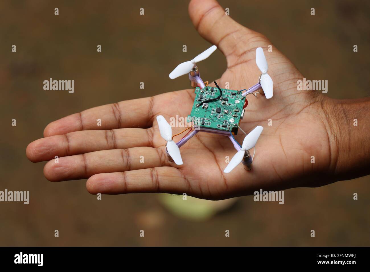 Nano drone chiamato anche da nomi mini droni o quad copter tenuto in mano. Piccolo drone volante modello portatile Foto Stock