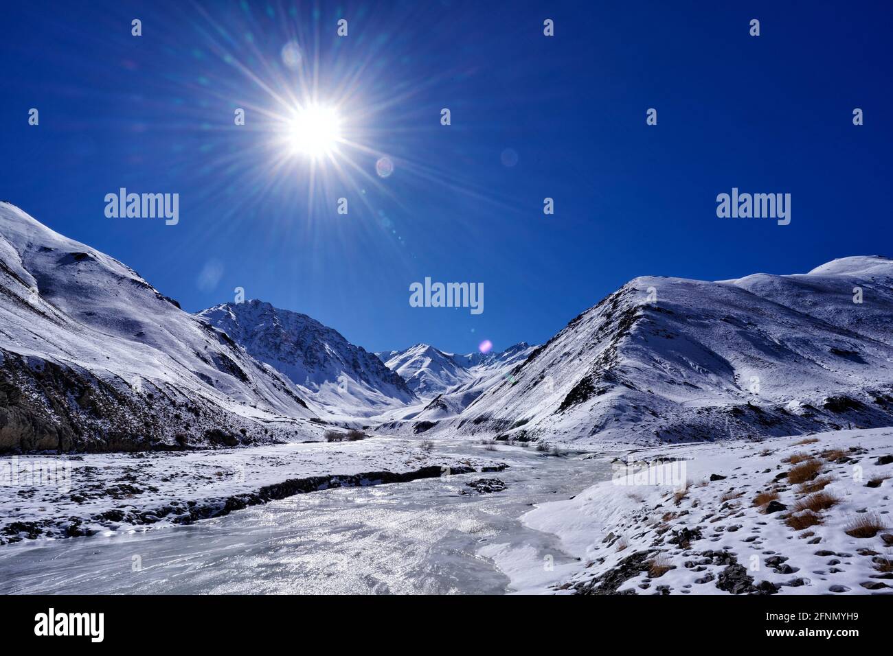 Strada per Rumbak Valley e Yarutse, Hemis NP, Ladak, India. Fiume con neve durante l'inverno, Himalaya. Paesaggio di montagna in India natura selvaggia. Sole da Foto Stock