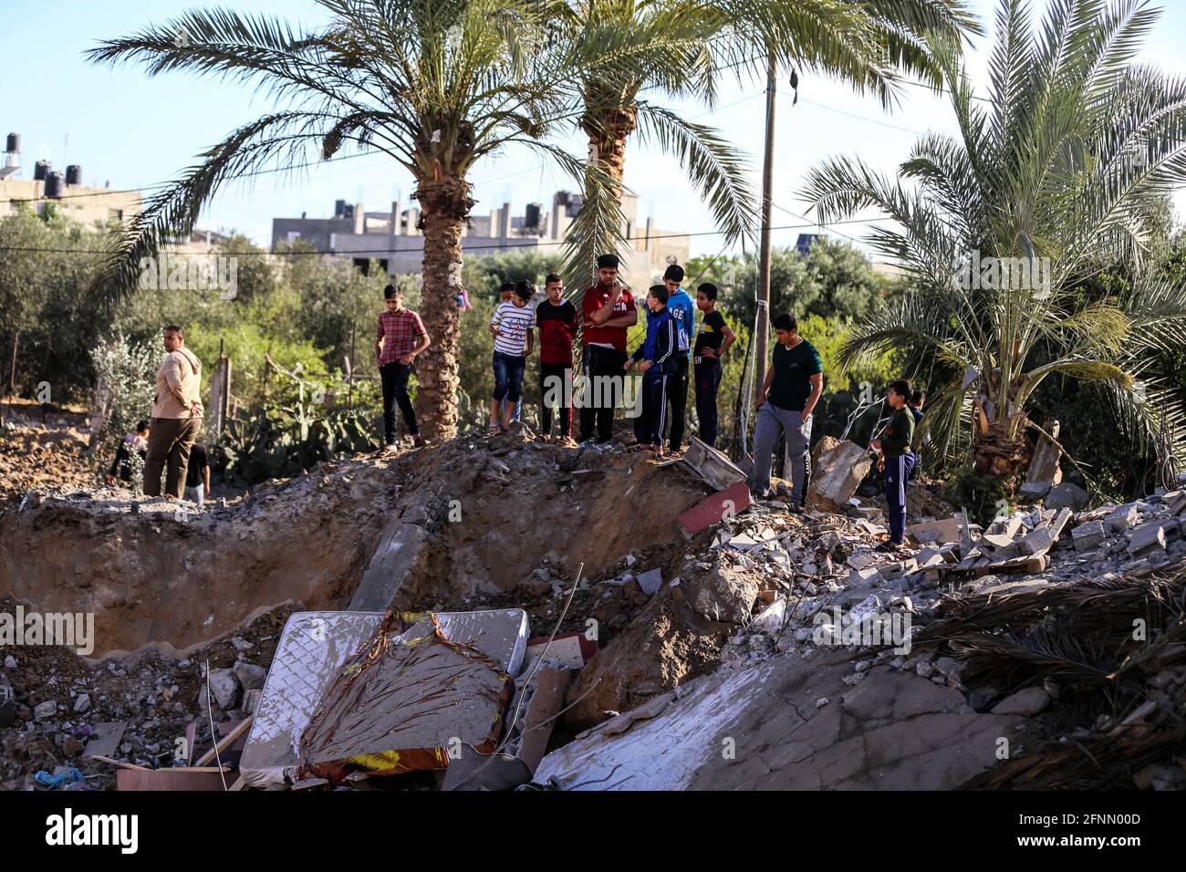 Gaza. 18 maggio 2021. I palestinesi ispezionano i detriti di una casa distrutta durante un attacco aereo israeliano nella città di Khan Younis, nella striscia di Gaza meridionale, il 18 maggio 2021. Credit: Yasser Qudih/Xinhua/Alamy Live News Foto Stock