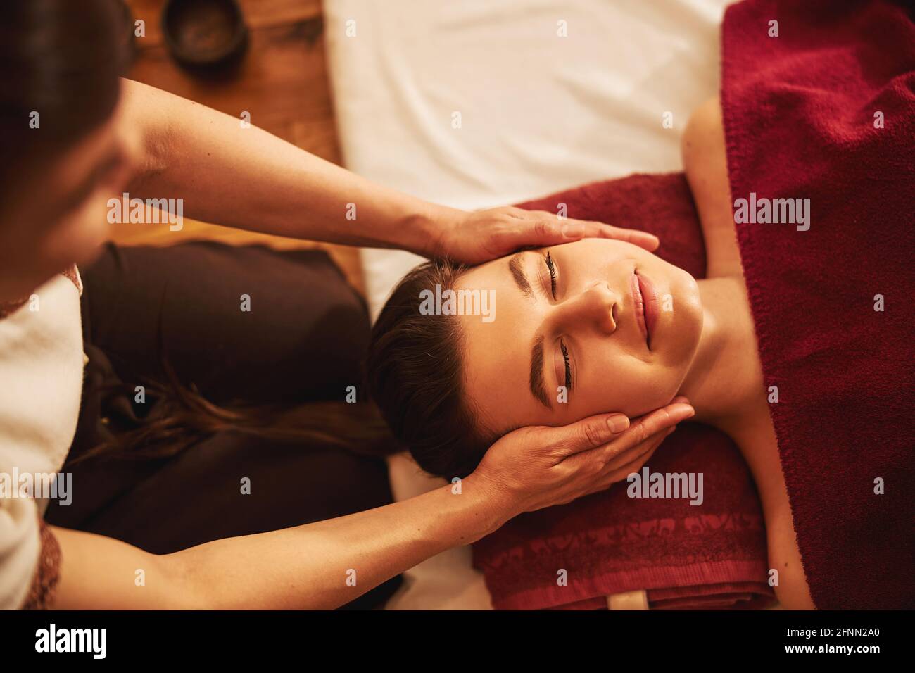 Volto di donna soddisfatto che riceve il massaggio delle guance Foto Stock