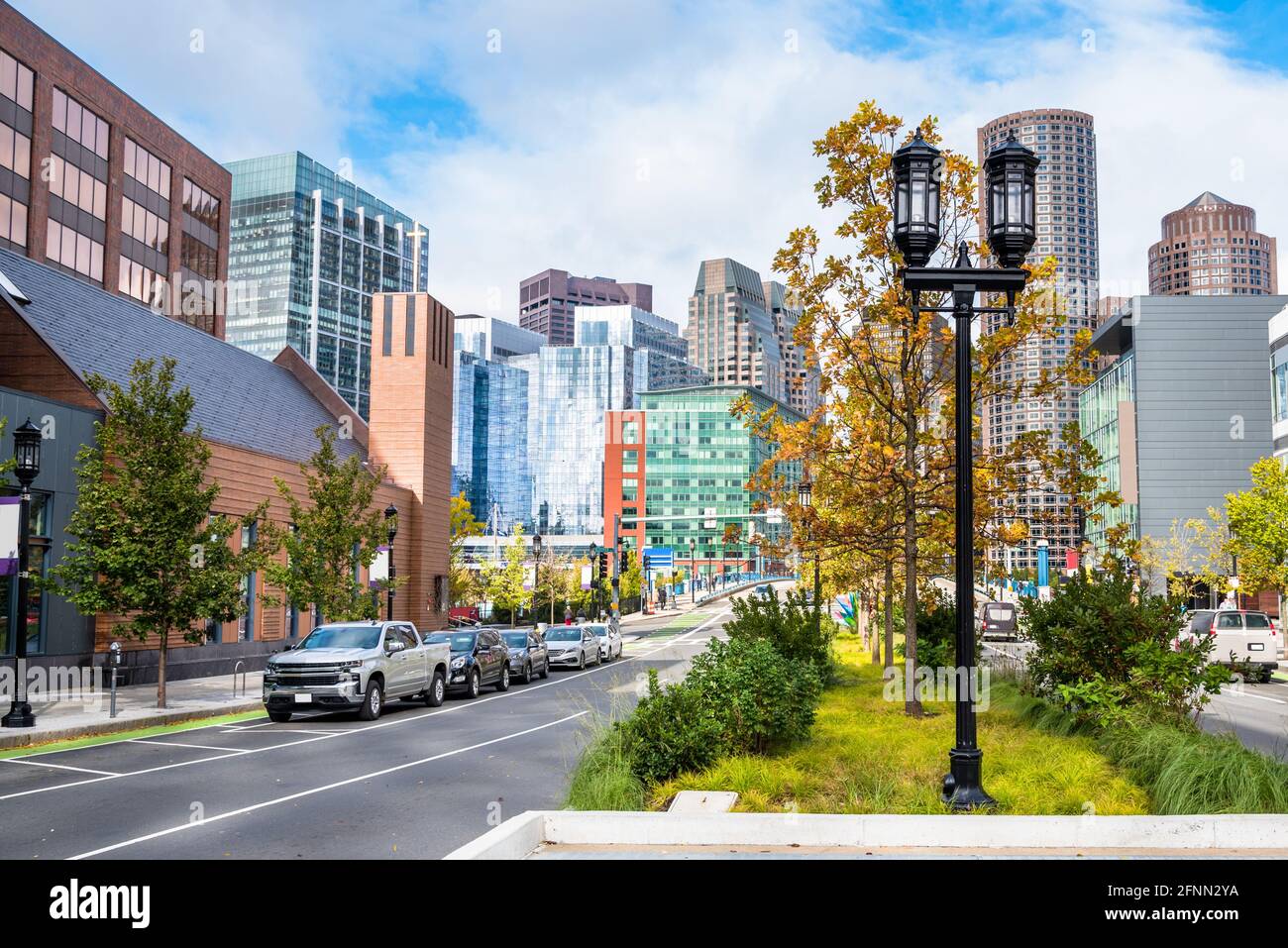 Vista dello skyline del quartiere finanziario di Boston da un ampio albero strada fiancheggiata in un giorno d'autunno parzialmente nuvoloso Foto Stock