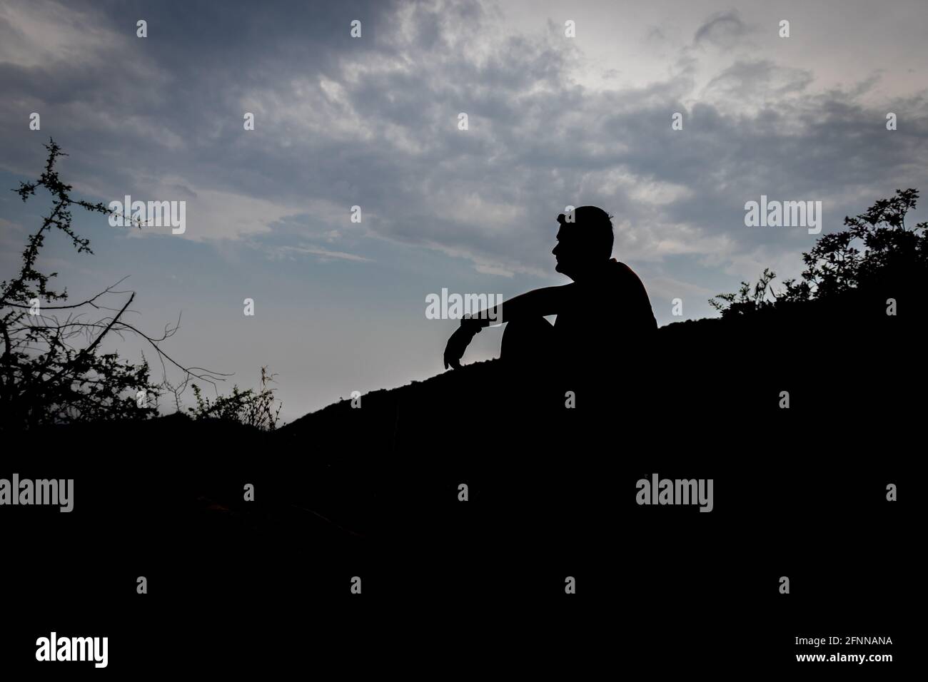 Uomo seduto ombra con cielo blu sfondo che mostra lo stato di solitudine Foto Stock