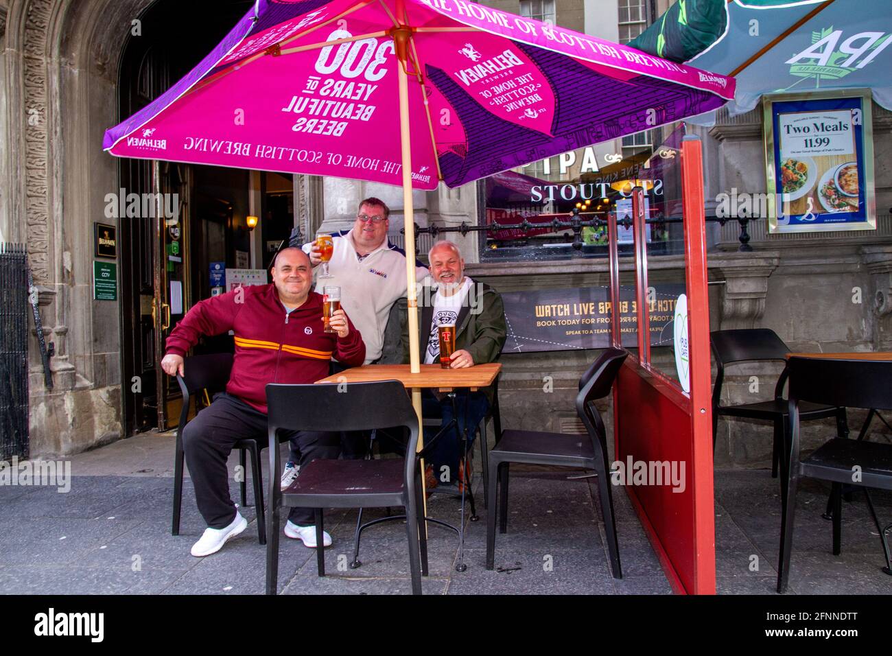 Dundee, Tayside, Scozia, Regno Unito. 18 maggio 2021. Regno Unito tempo: Caldo sole di primavera attraverso la Scozia nord-orientale con temperature che raggiungono i 15°C. Le restrizioni di blocco del Covid-19 sono ora rilassate al livello 2 a Dundee, vedendo le persone che approfittano delle nuove normative facilitate e socializzando all'interno e all'esterno dei pub locali. Le restrizioni di livello 2 consentono ai pub Dundee di rimanere aperti per affari fino alle 22:30 con i clienti che si godono il tempo bevendo al bar Old Bank nel centro della città. Credit: Dundee Photographics/Alamy Live News Foto Stock