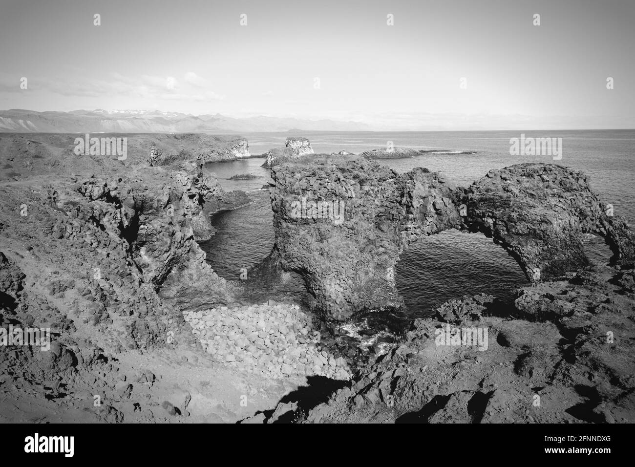 Arco naturale di roccia in Arnarstapi, penisola di Snafellsnes, Islanda. Tono bianco e nero. Foto Stock