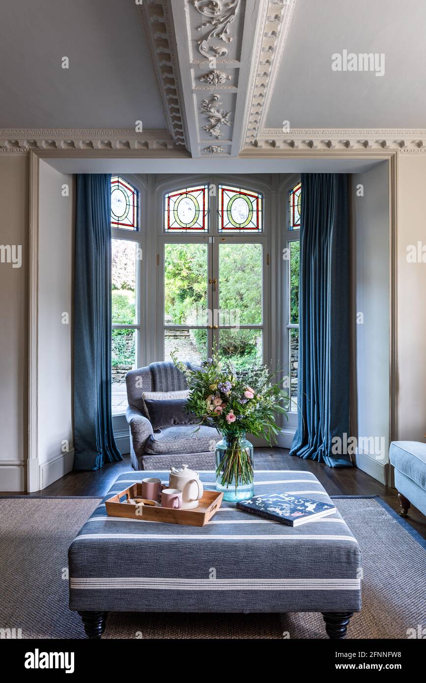 Ottomano in Gray Seal con doppie porte al giardino in Jacobean Wool Merchant's casa, Somerset. Foto Stock