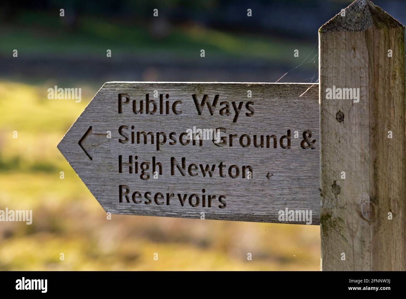 Segnaletica per vie pubbliche a Cumbria, Inghilterra. Il cartello indica la strada per Simpson Ground e High Newton Reservoir. Foto Stock