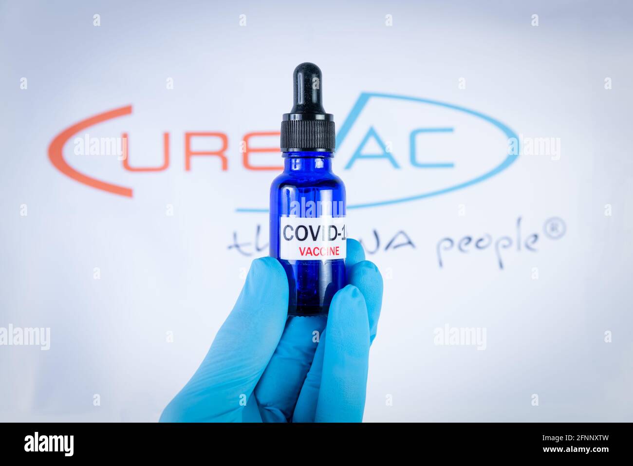 Una mano tiene il flaconcino davanti al logo del vaccino Curevac a Barcellona, Spagna, il 18 maggio 2021. Curevac è un nuovo vaccino a base di RNA Covid19 prodotto in Germania Foto Stock