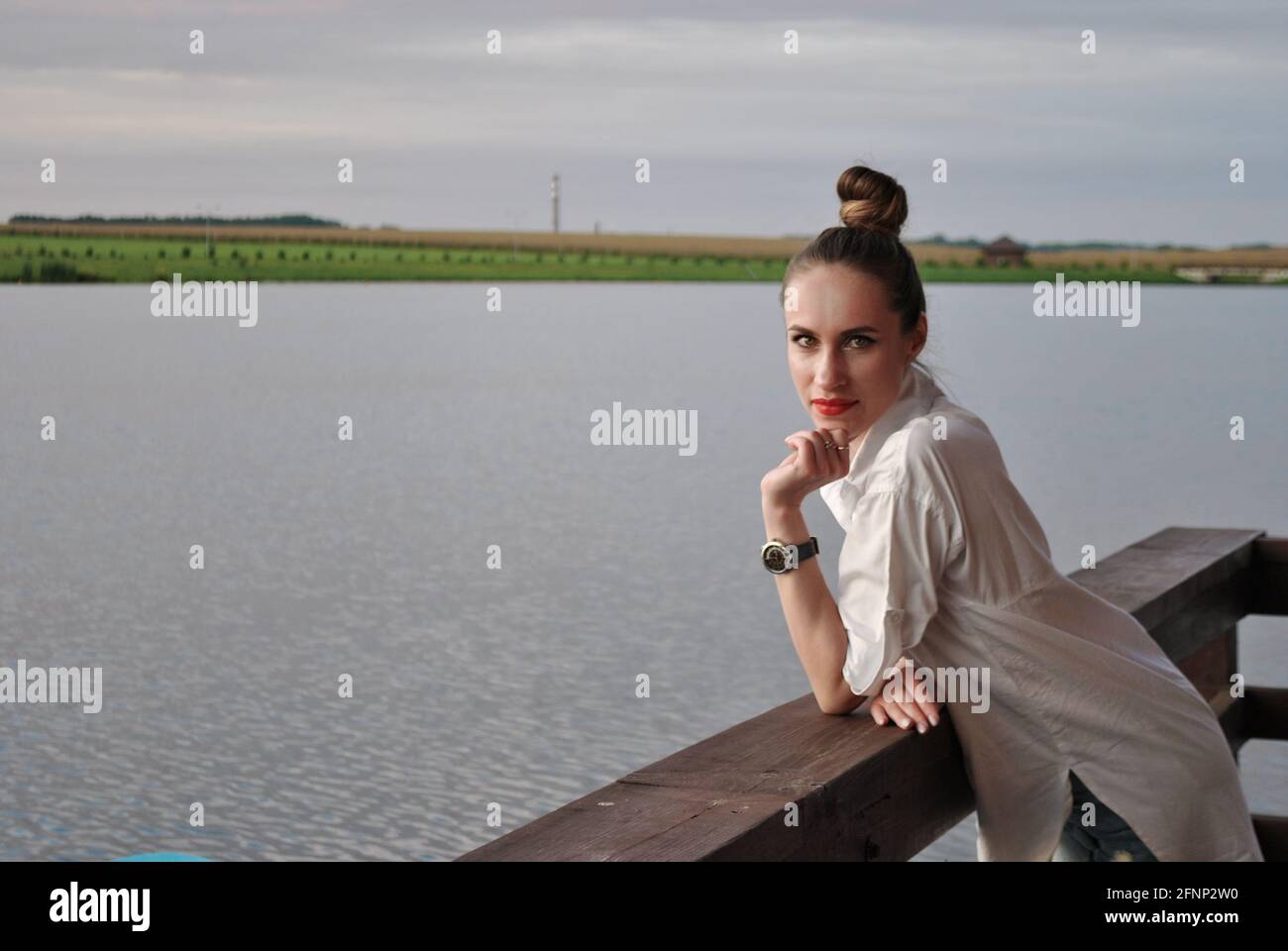 ritratto di una bella giovane donna sulla riva del lago, uno sguardo al telespettatore Foto Stock
