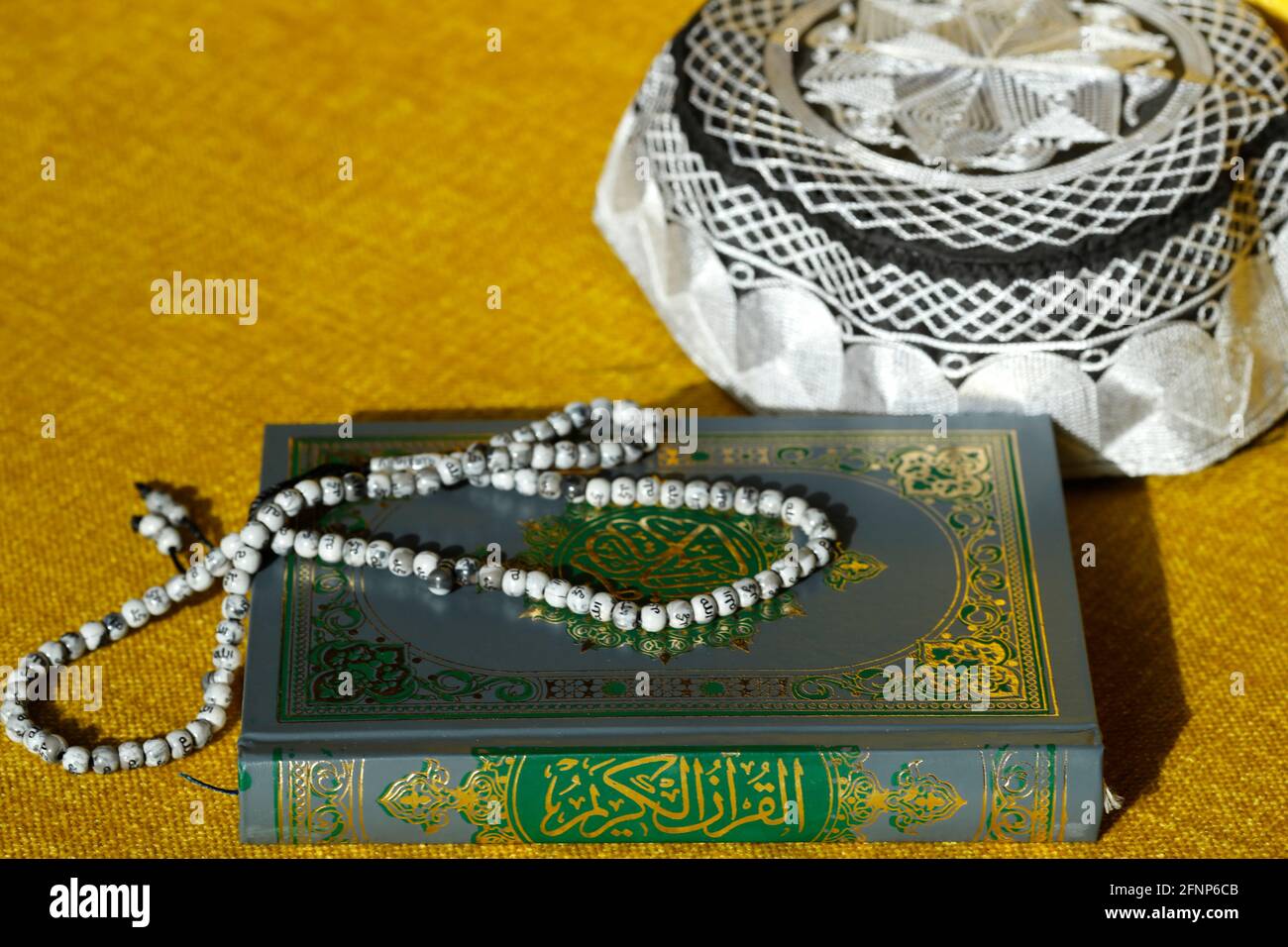 Corano, cappellino Kufi e perle di preghiera ( misbaha ) . Simboli dell'Islam. Dubai. Emirati Arabi Uniti Foto Stock