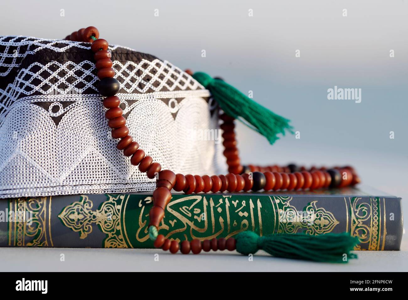 Corano, cappellino Kufi e perle di preghiera ( misbaha ) . Simboli dell'Islam. Emirati Arabi Uniti Foto Stock