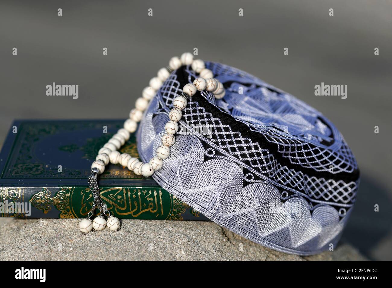 Corano, cappellino Kufi e perle di preghiera ( misbaha ) . Simboli dell'Islam. Emirati Arabi Uniti Foto Stock