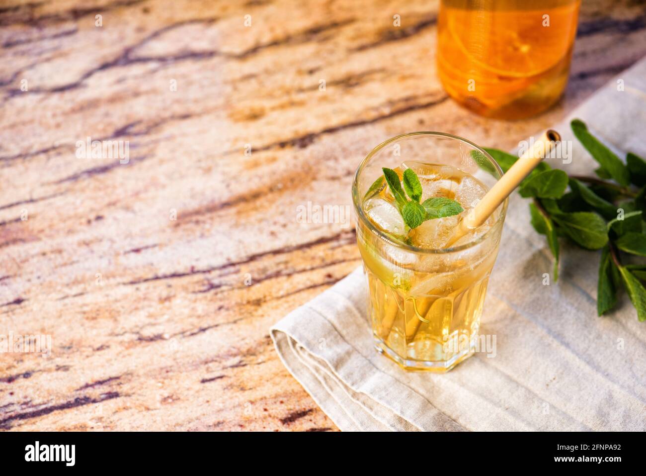 Il bicchiere di tè ghiacciato agli agrumi su un tavolo di marmo. Cuba Libre o cocktail a lunga isola, bevanda fredda o limonata con frutta e menta. Spazio di copia per il Foto Stock