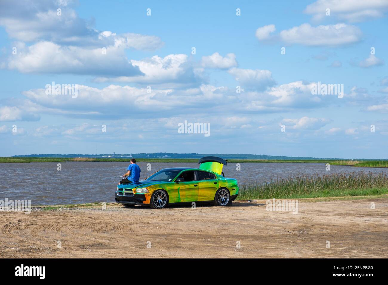 CYPREMORT POINT STATE PARK, LA, USA - 13 MAGGIO 2021: L'uomo pesca dal cofano di un'auto personalizzata con un lavoro di verniciatura a colori variabile Foto Stock