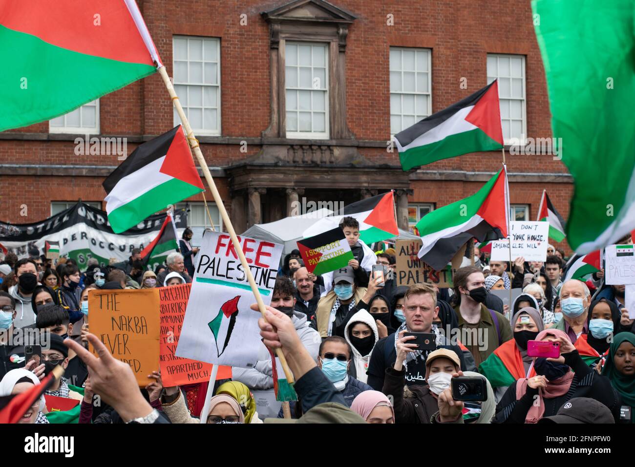 Folla di manifestanti al raduno della Palestina libera, Platt Fields con bandiere palestinesi e pakistane. Platt Hall Costume Museum, Rusholme, Manchester Foto Stock