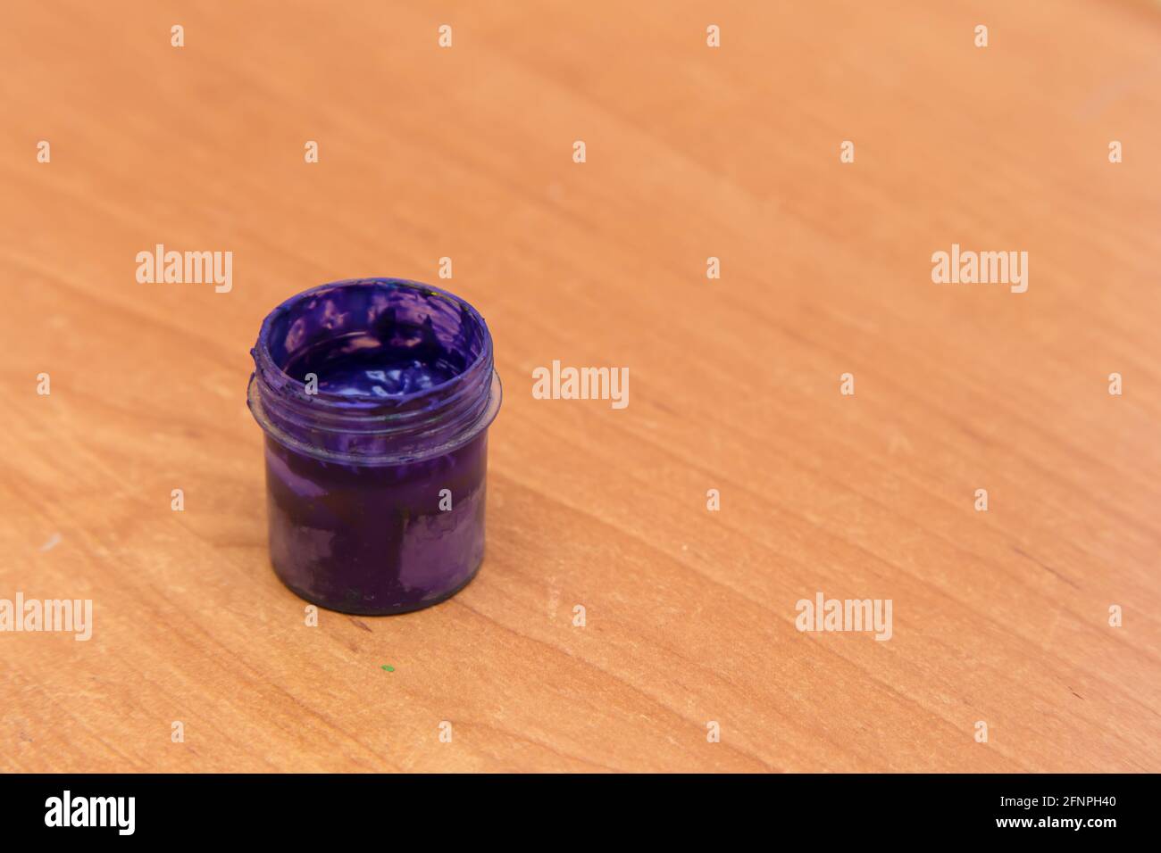 Un vaso aperto di gouache viola usate per la pittura e la creatività. Vista laterale di una latta di vernice gouache a metà vuoto. Spazio per la copia vuoto. Foto Stock