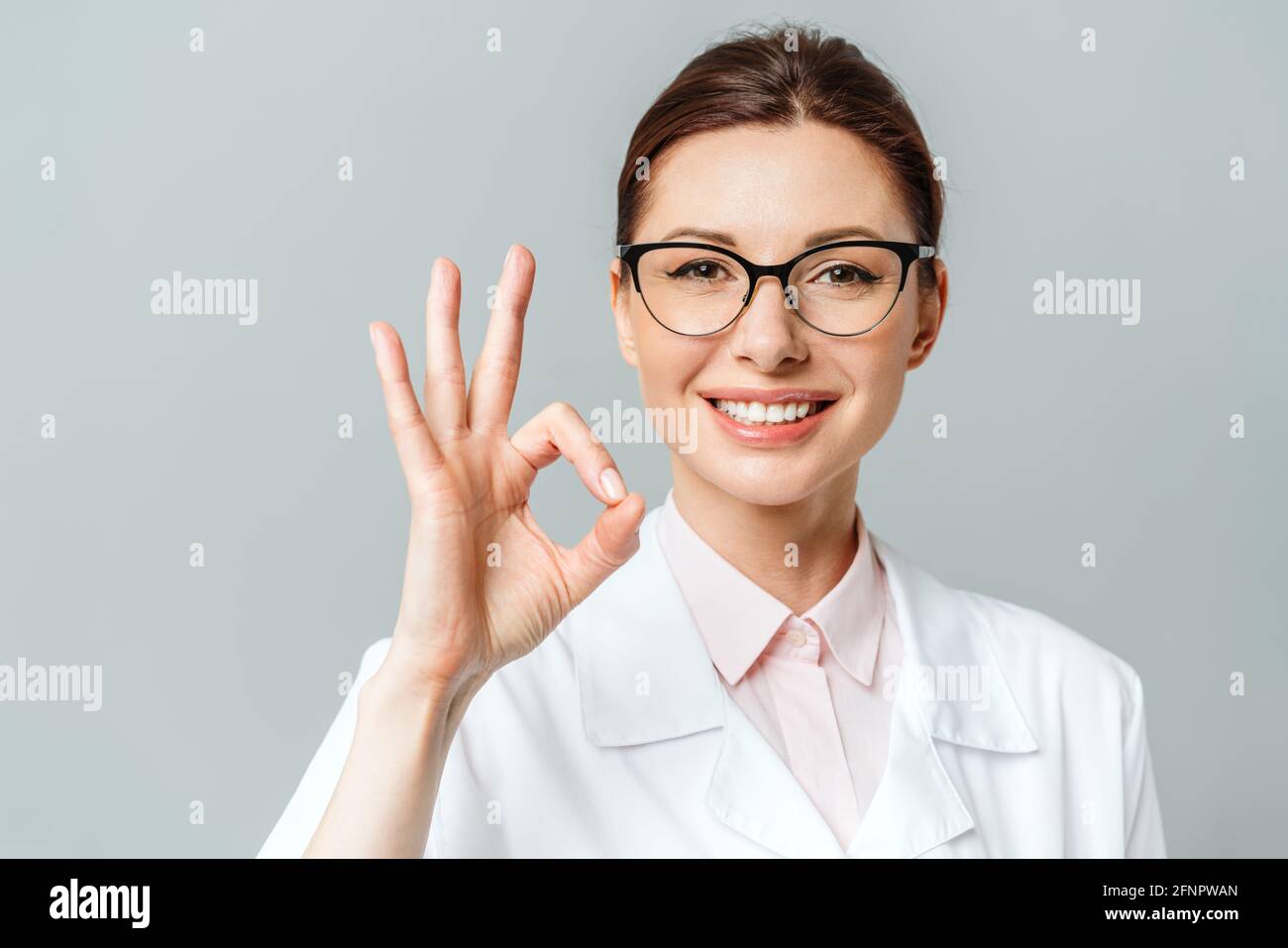 Ritratto di una donna felice medico che mostra il segno OK Foto Stock