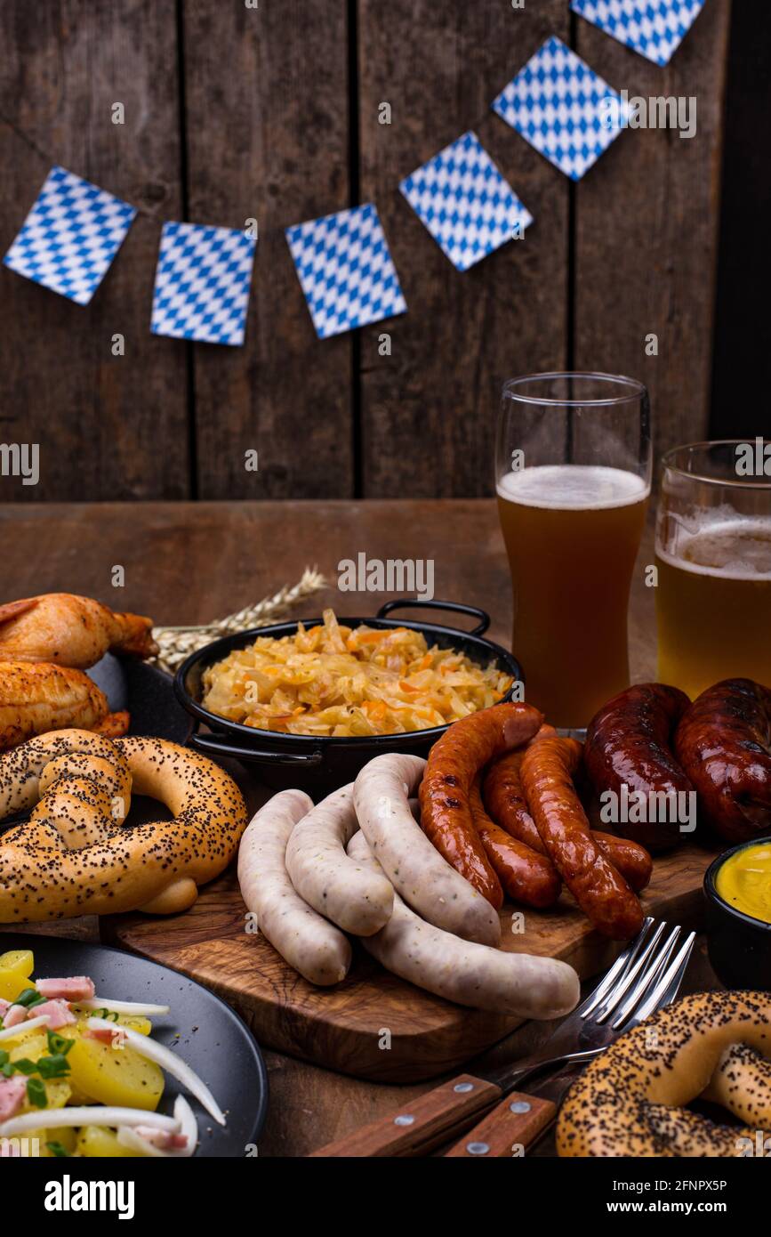 Piatti Oktoberfest con birra, pretzel e salsiccia Foto Stock