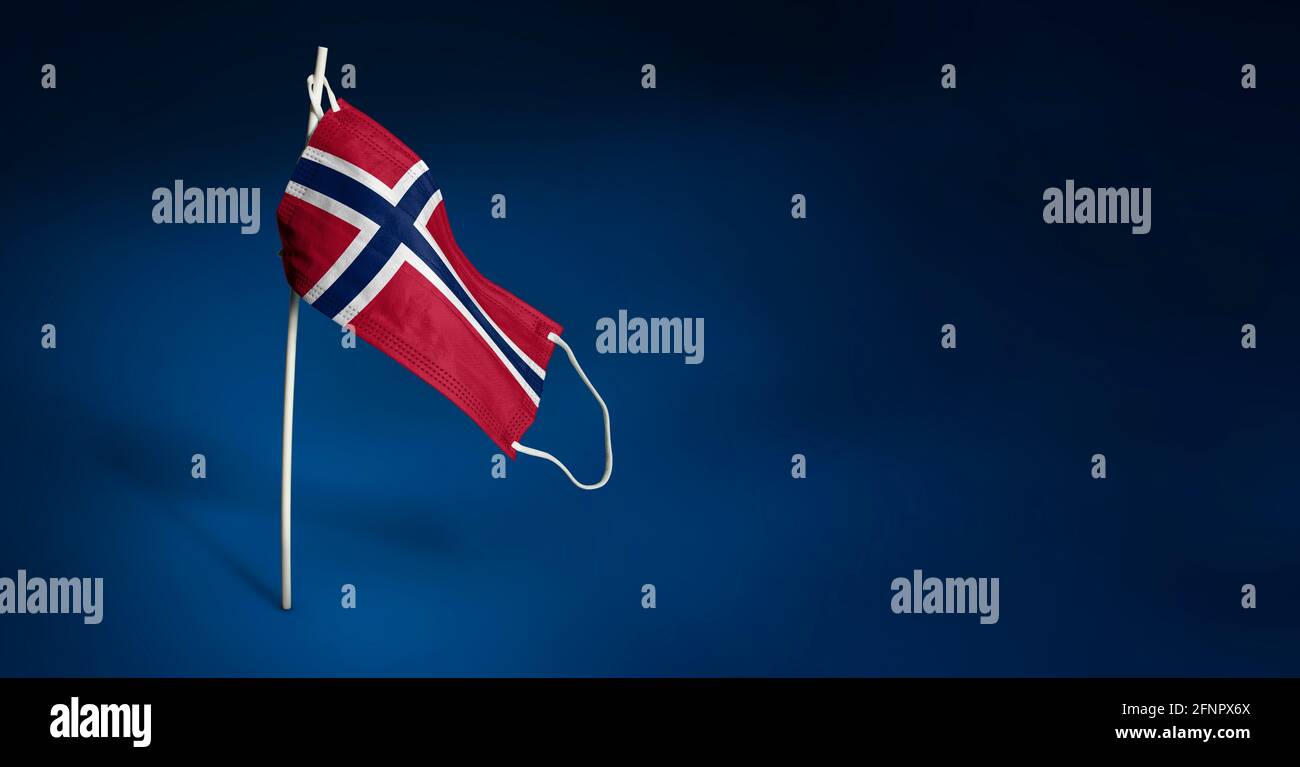 Maschera norvegese su sfondo blu scuro. Bandiera sventolante della Norvegia dipinta su maschera medica sul palo. Flag di attacco del virus. Concetto della bandiera della lotta agai Foto Stock