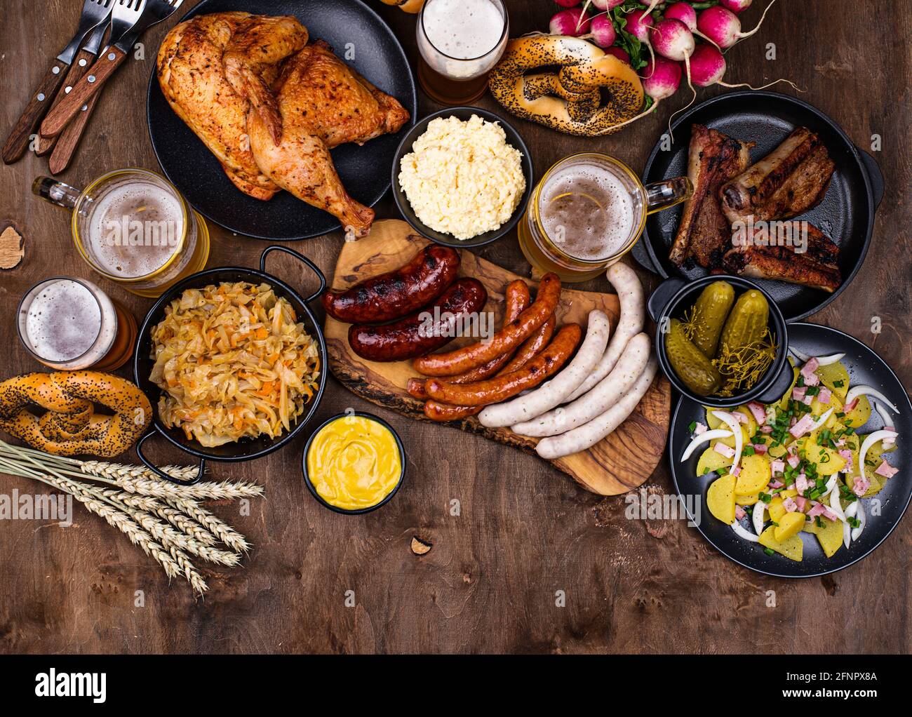Piatti Oktoberfest con birra, pretzel e salsiccia Foto Stock
