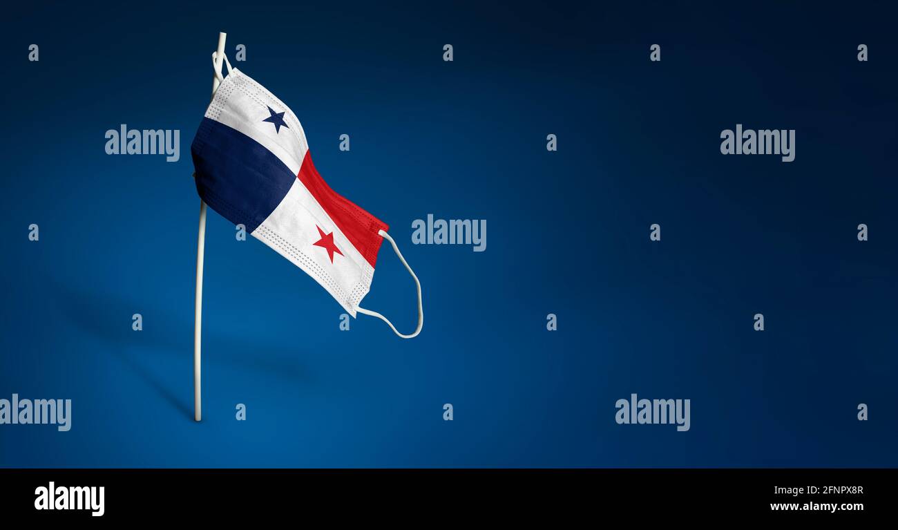 Maschera Panama su sfondo blu scuro. Bandiera ondulata di Panama dipinta su maschera medica sul palo. Flag di attacco del virus. Concetto della bandiera della lotta agai Foto Stock