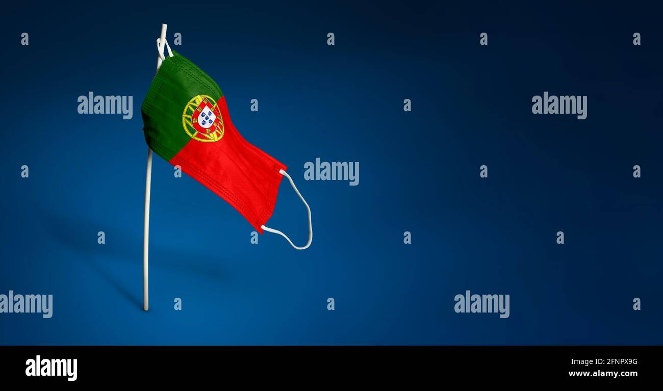 Maschera Portogallo su sfondo blu scuro. Bandiera ondulata del Portogallo dipinta su maschera medica sul palo. Flag di attacco del virus. Concetto della bandiera della lotta Foto Stock