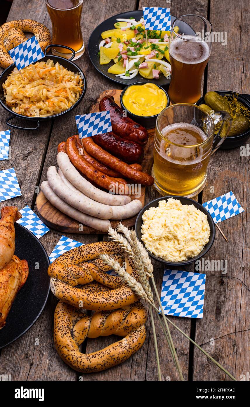 Piatti Oktoberfest con birra, pretzel e salsiccia Foto Stock