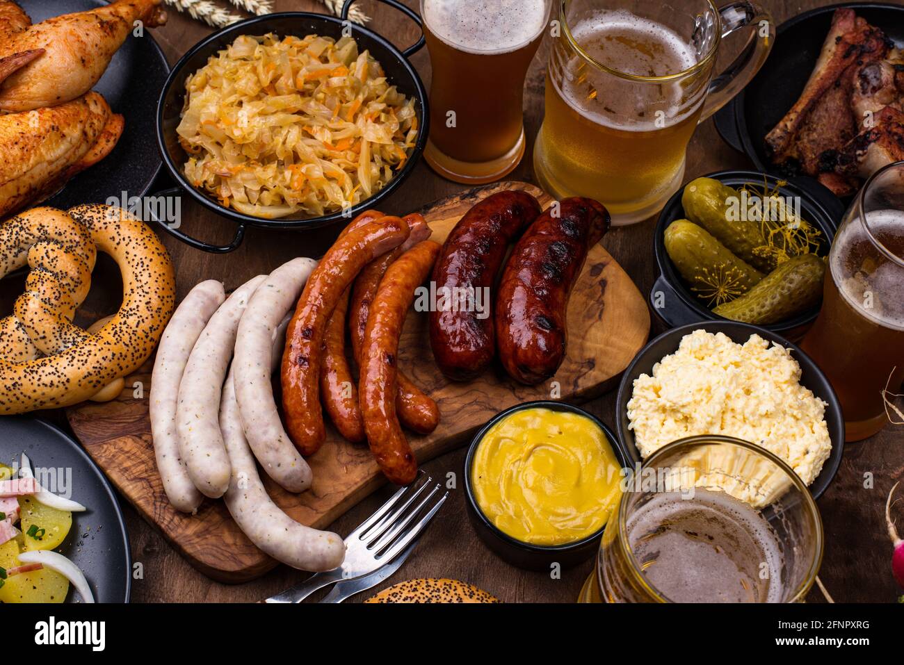 Piatti Oktoberfest con birra, pretzel e salsiccia Foto Stock