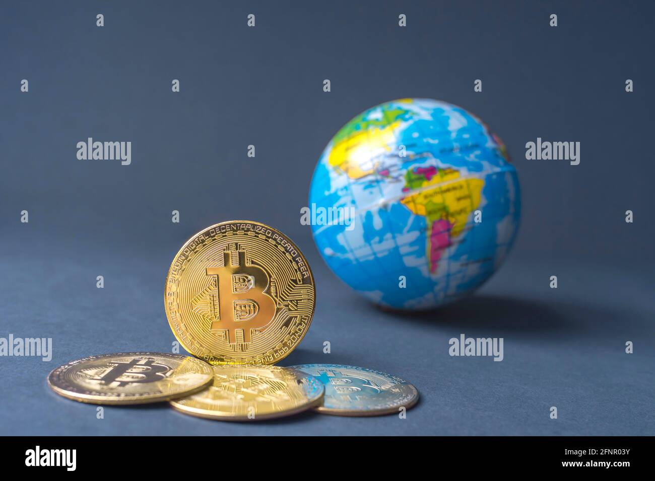 Bitcoin BTC criptovaluta monete d'oro e globo terrestre, concetto mondiale di denaro virtuale. Tecnologia mineraria o blockchain Foto Stock