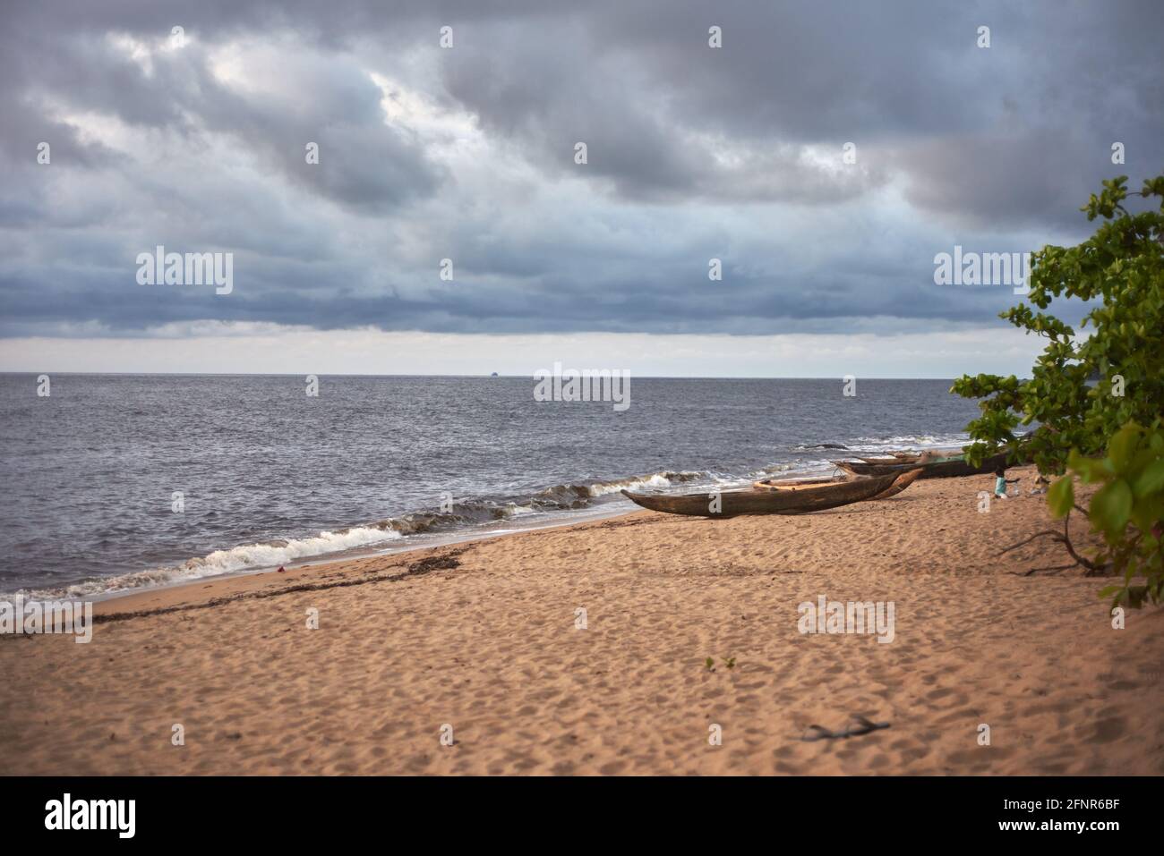Cannoni in legno Dugout sulla spiaggia di sabbia di Kribi su una nuvolosa giorno Foto Stock