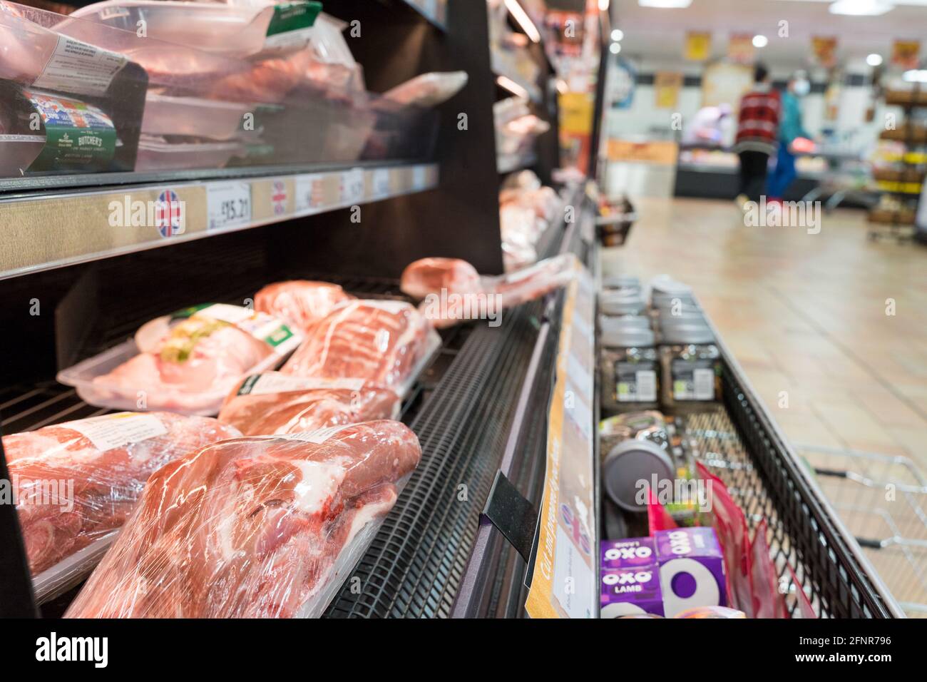 giunti di agnello a base di carne cruda avvolti in pellicola trasparente in esposizione In vendita al supermercato Morrisons Foto Stock
