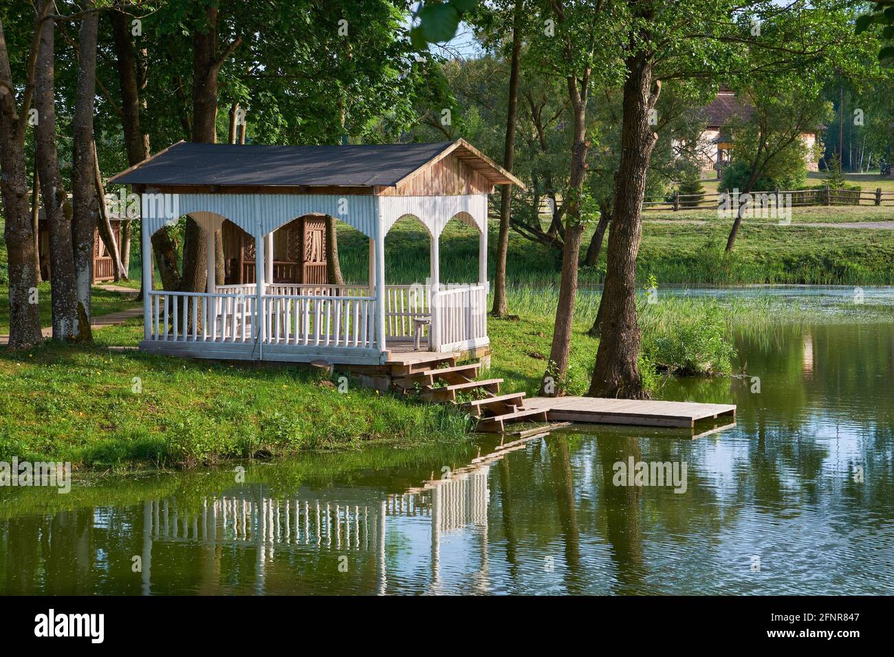 Gazebo estivo sulla riva dello stagno. Pergola di legno a Merechevshchina, luogo di nascita di Tadeusz Kosciuszko, vicino al villaggio di Kossovo Brest regione, Bielorussia. Foto Stock