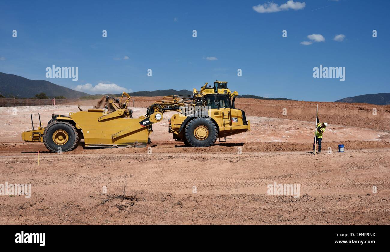 Un operatore di attrezzature pesanti utilizza un raschiatore per trattori gommati Caterpillar 623H per rimuovere lo sporco nel cantiere di miglioramento dell'autostrada a Santa Fe, New Mexico. Foto Stock