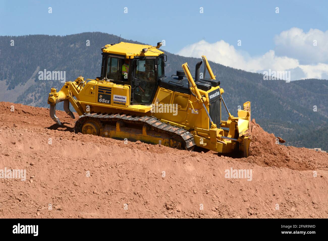 Un lavoratore utilizza un bulldozer cingolato Komatsu 65EX per spostare lo sporco in un cantiere di miglioramento autostradale a Santa Fe, New Mexico. Foto Stock