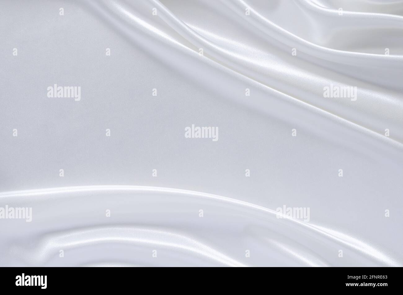 Elegante tessuto satinato bianco ondulato e liscio. Astratto, struttura e concetto di matrimonio. Foto Stock