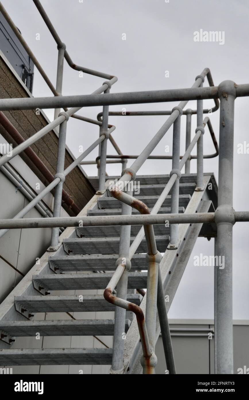 Set di scale o gradini di accesso di sicurezza in metallo o acciaio in un sito industriale che conduce a una torre di raffreddamento Foto Stock