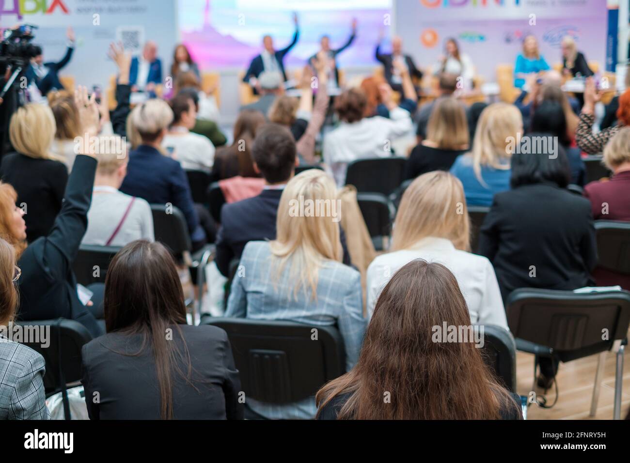 Gruppo di uomini d'affari che alzano le mani durante la conferenza Foto Stock