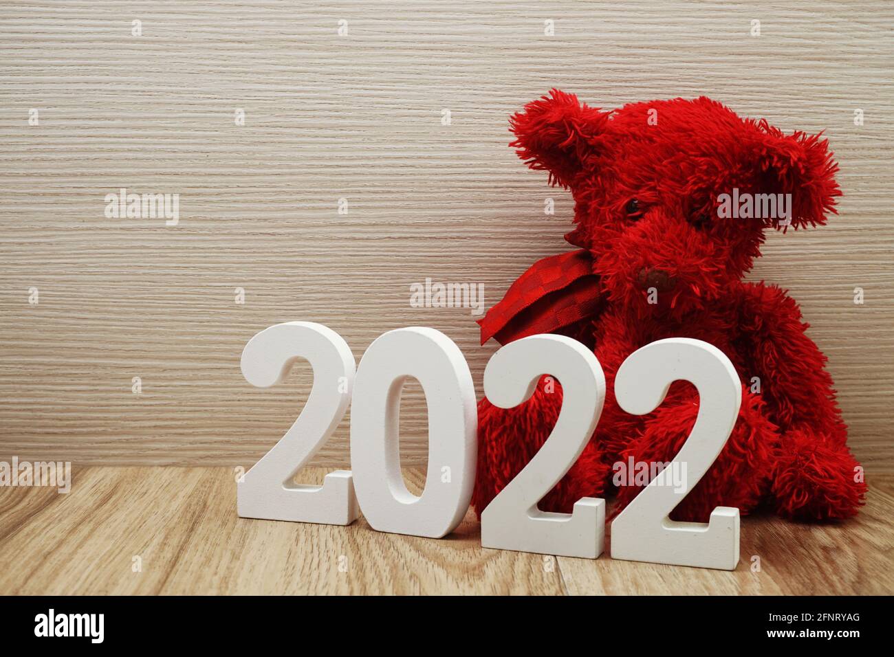 Felice anno nuovo 2022 sfondo festivo e decorazione orsacchiotto su sfondo di legno Foto Stock