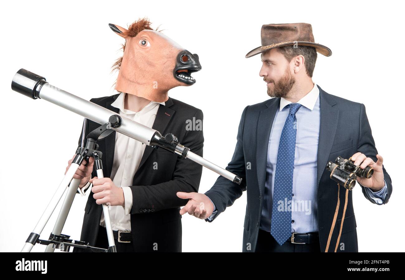 Uomo d'affari in testa a cavallo maschera tenere telescopio e uomo cowboy con binocolo, visione d'affari Foto Stock