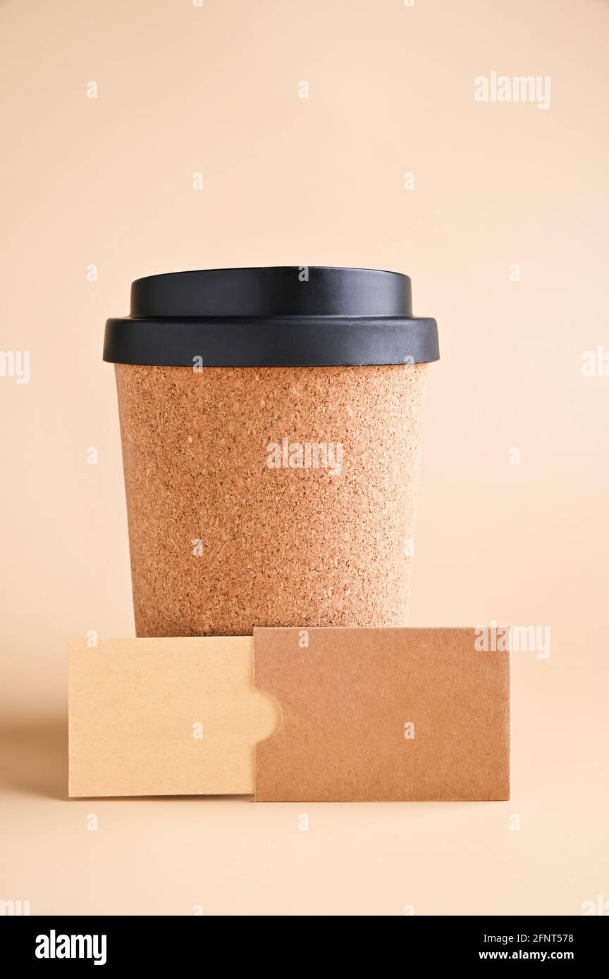 Mockup di biglietto da visita, carta kraft eco su sfondo beige. Una tazza per il caffè da utilizzare fatta con materie prime riciclate. Concetto di cancelleria eco-compatibile. Foto di alta qualità. Spazio di copia Foto Stock