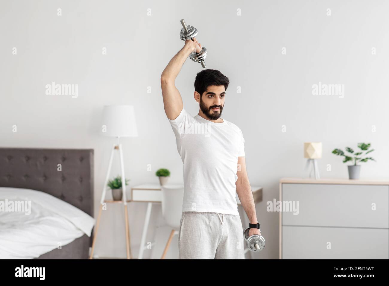 Prendersi cura del corpo e dello stile di vita sano a casa, l'allenamento di forza per i muscoli durante la pandemia di covid-19 Foto Stock