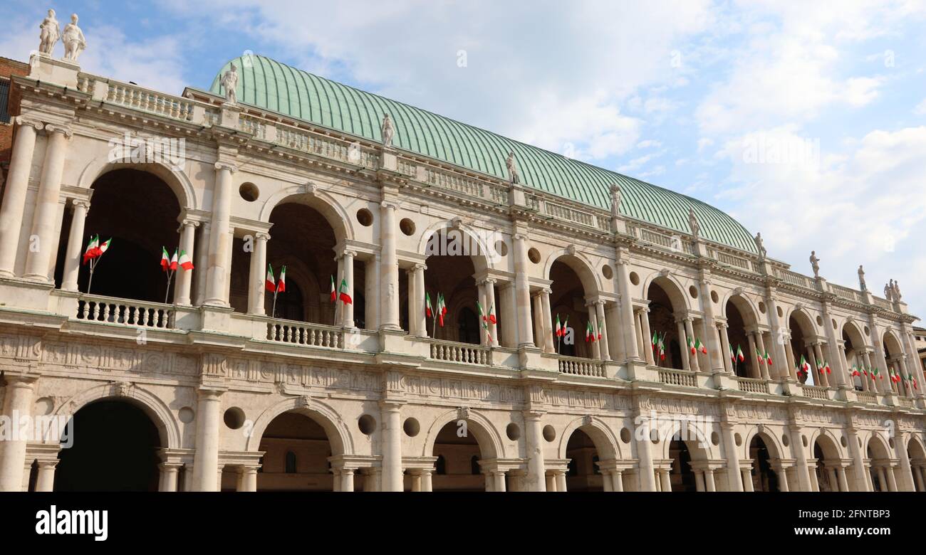 Monumento storico chiamato Basilica Palladiana nella città di Vicenza Con le tante bandiere che volano durante la giornata della Repubblica Italiana Foto Stock