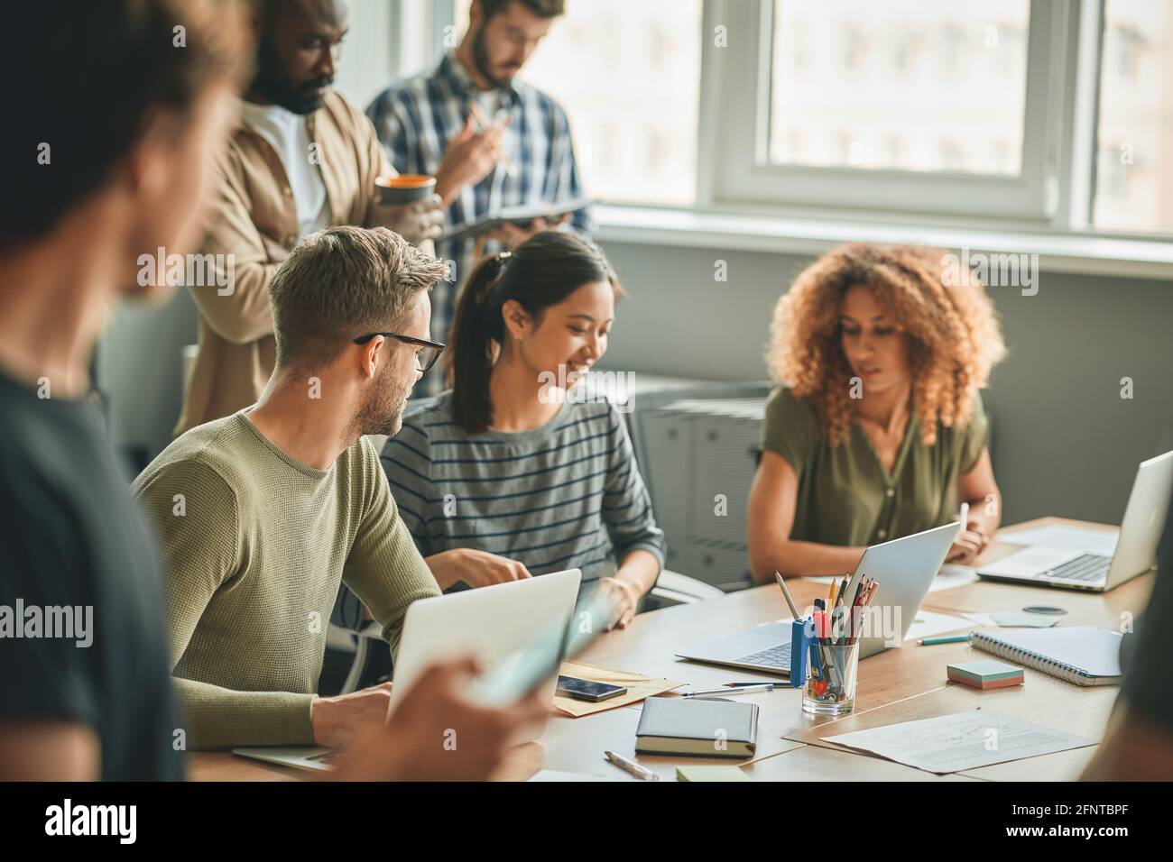 Giovani colleghi che lavorano insieme per alcuni compiti di lavoro Foto Stock
