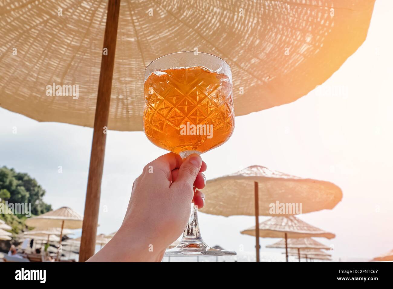 Mano femminile che tiene un bicchiere con Aperol Spritz Foto Stock