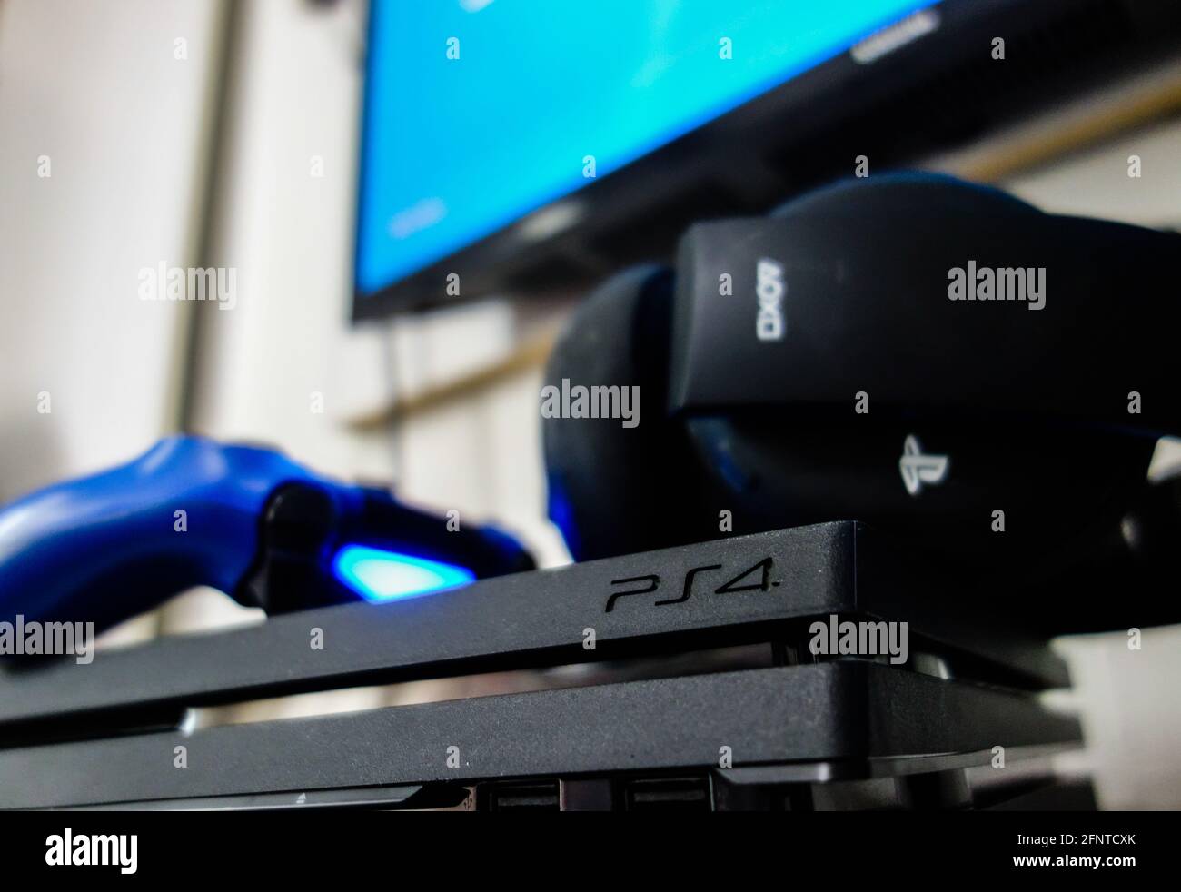 SAO PAULO, BRASILE - 04 maggio 2021: Console di gioco PlayStation 4 Pro nera Sony con controller wireless blu e cuffie per giochi. Simbolo PS4 Foto Stock