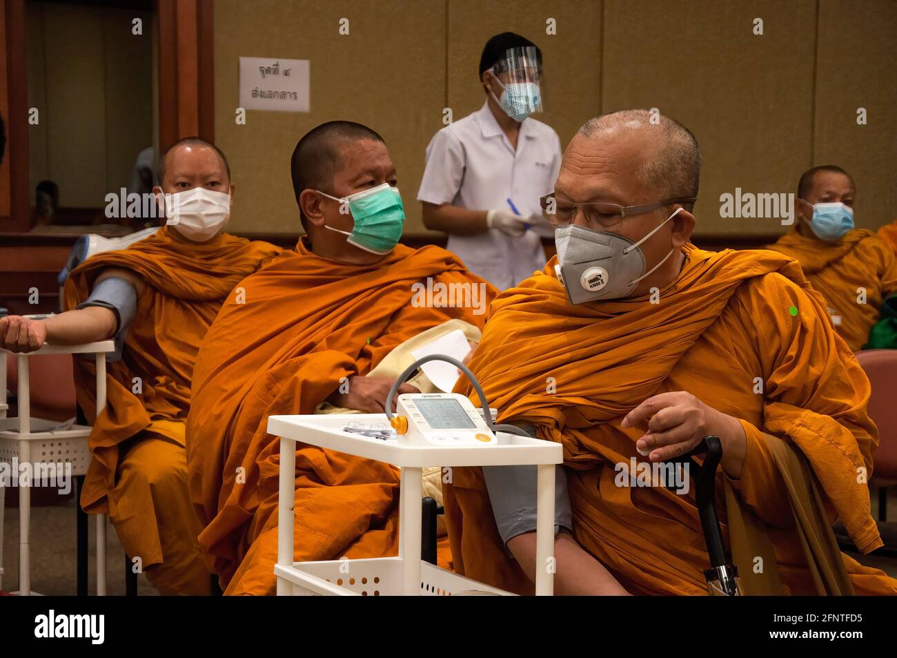 Un monaco buddista thailandese ha la sua pressione sanguigna misurata prima di ricevere un vaccino Sinovac durante un viaggio di vaccinazione contro la pandemia di coronavirus COVID-19 presso il Priest Hospital di Bangkok. Foto Stock