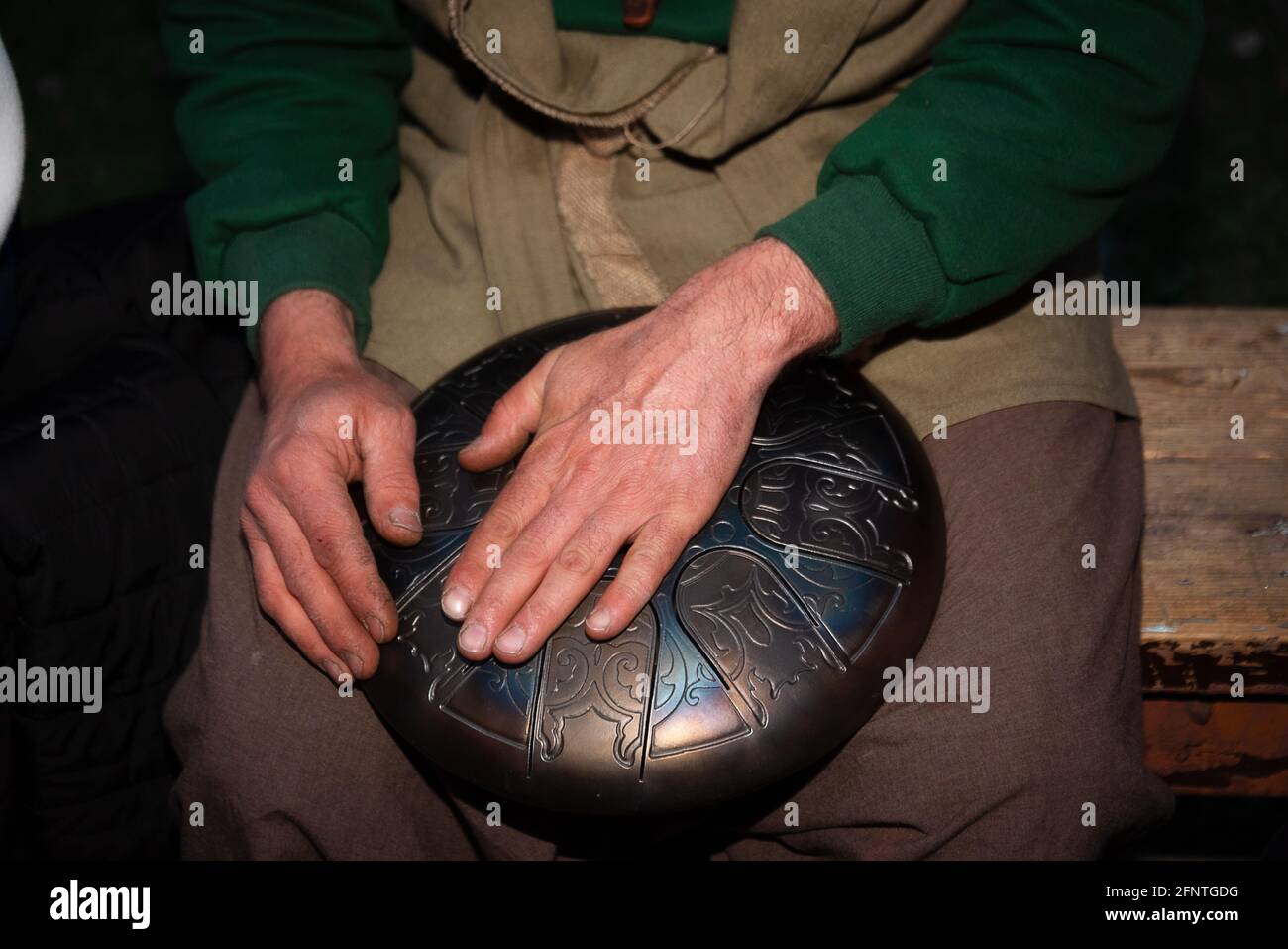 Le mani ruvide maschili suonano musica su uno strumento musicale glucofono Foto Stock