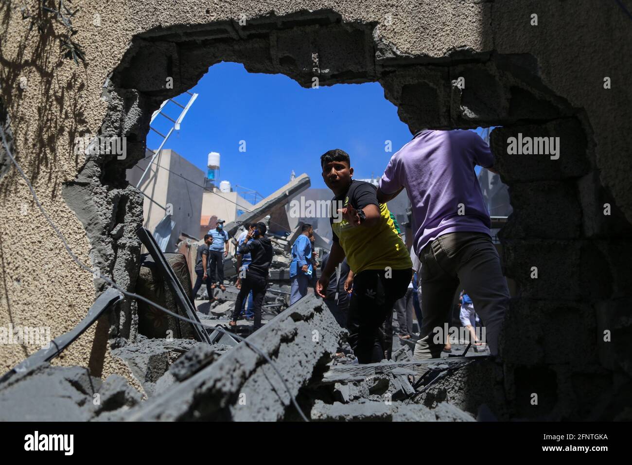 Gaza. 19 maggio 2021. I palestinesi ispezionano un edificio distrutto dopo un attacco aereo israeliano nella parte meridionale della striscia di Gaza, Khan Younis, il 19 maggio 2021. Credit: Yasser Qudih/Xinhua/Alamy Live News Foto Stock