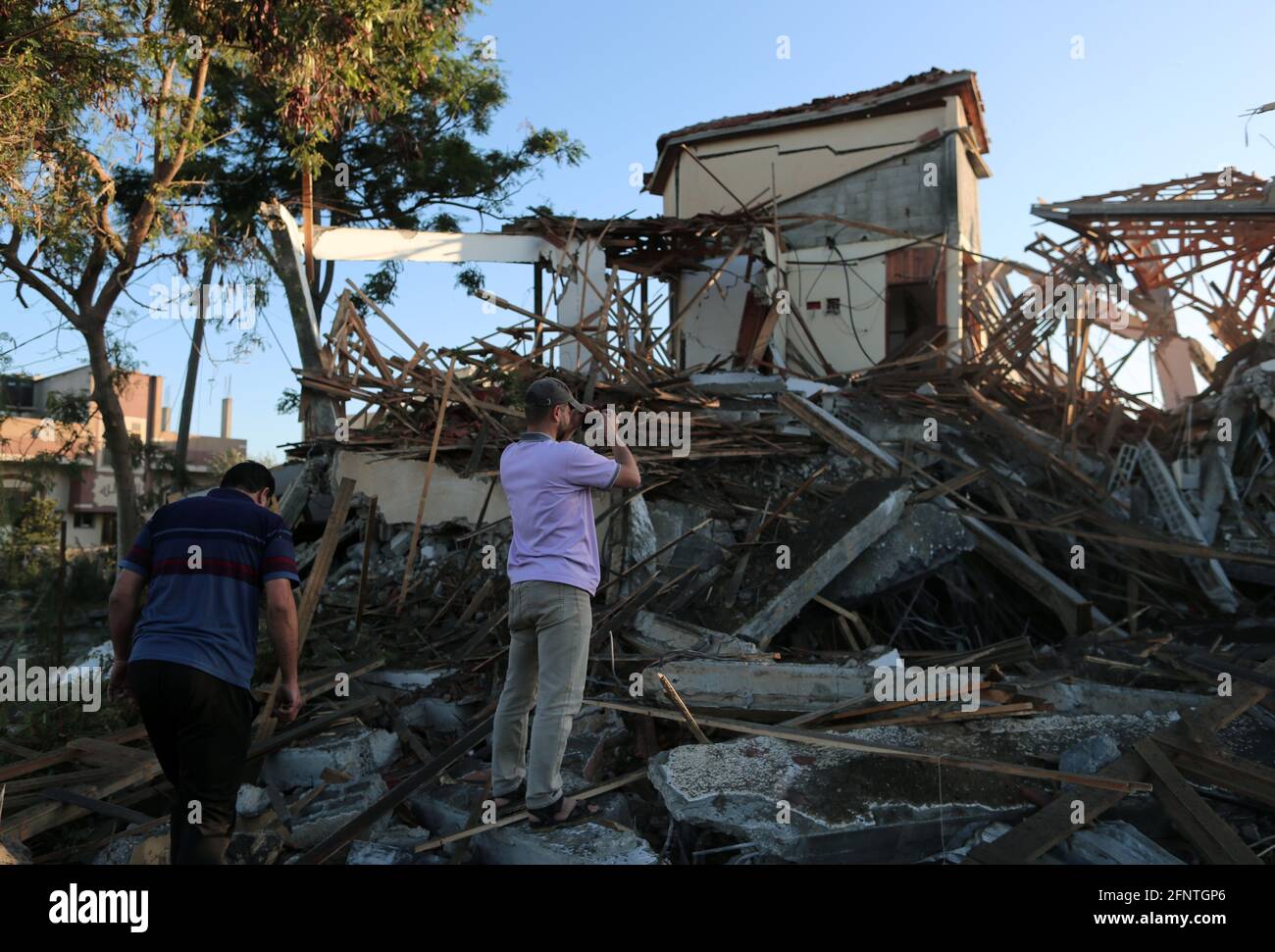 (210519) -- GAZA, 19 maggio 2021 (Xinhua) -- i palestinesi ispezionano un edificio distrutto dopo un attacco aereo israeliano nella città di Khan Younis, nella striscia di Gaza meridionale, il 19 maggio 2021. (Foto di Yasser Qudih/Xinhua) Foto Stock