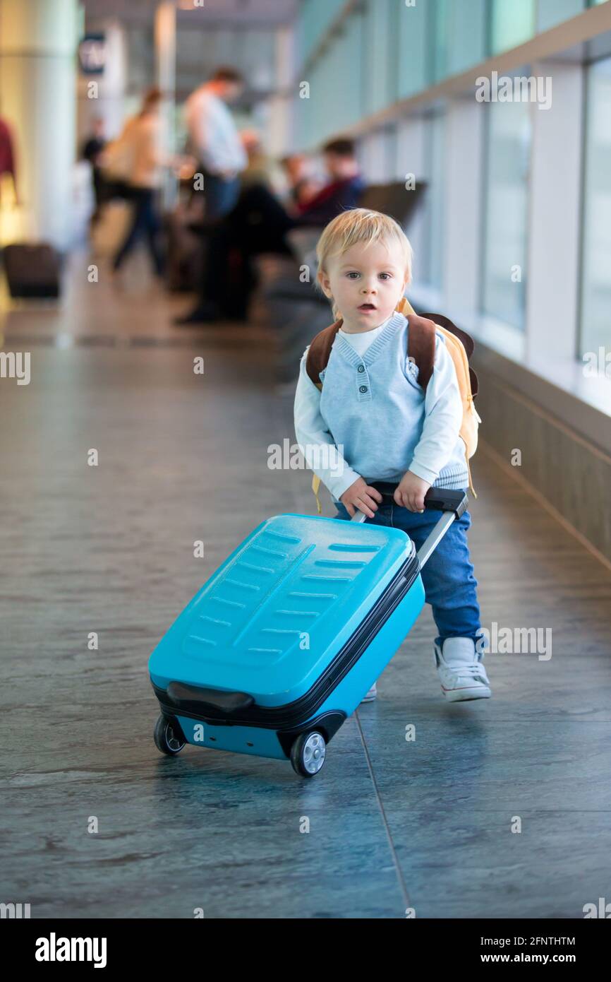 Bambino, valigia, in viaggio con la famiglia, in attesa all'aeroporto di  salire a bordo dell'aereo per una vacanza in famiglia Foto stock - Alamy