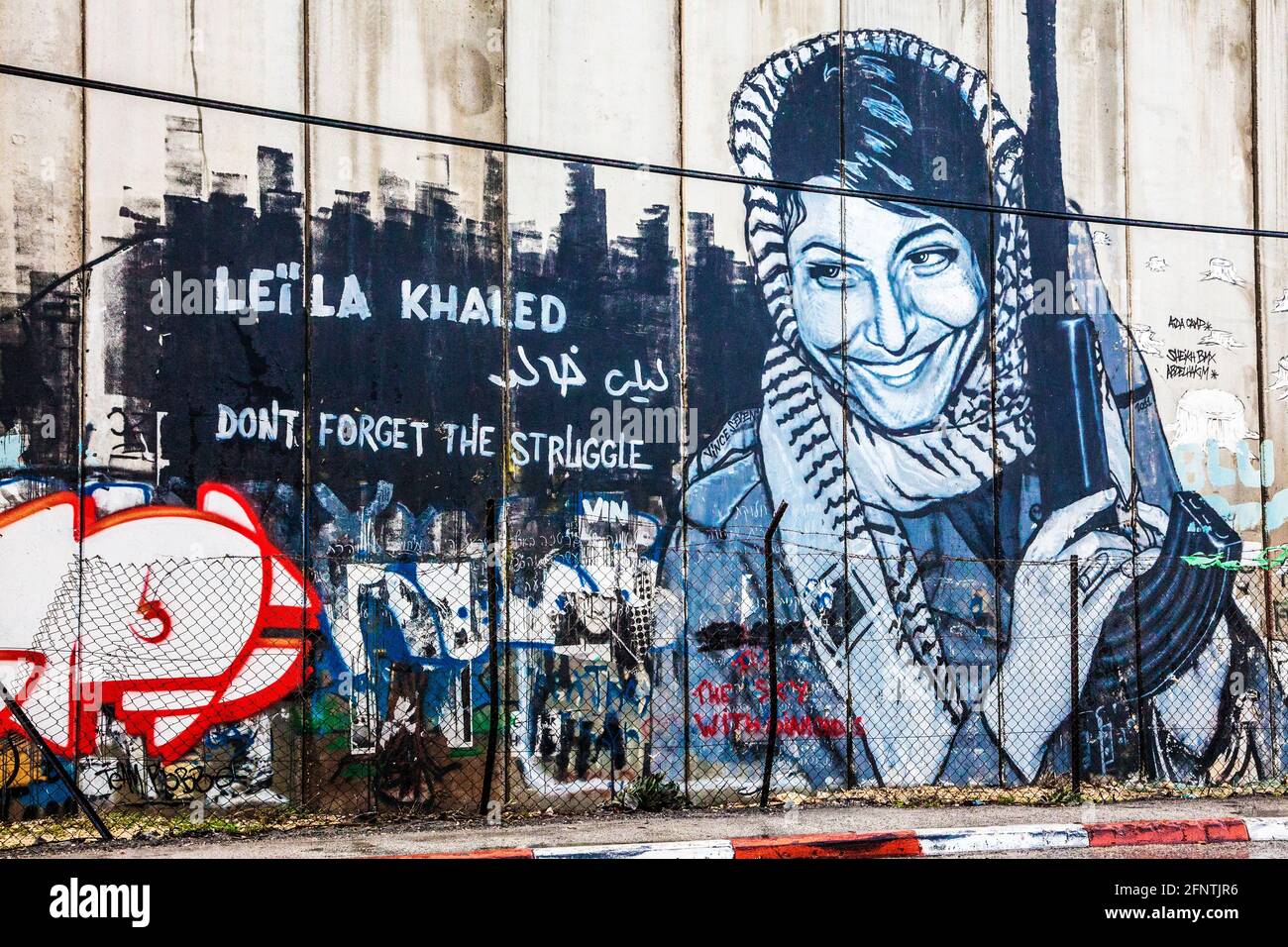 Graffiti di Leila Khaled sulla barriera israeliana della Cisgiordania vicino a Betlemme. Foto Stock